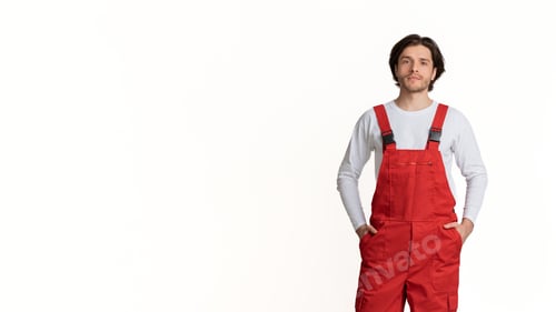 Preview: Portrait of young handyman wearing work clothes posing over light background