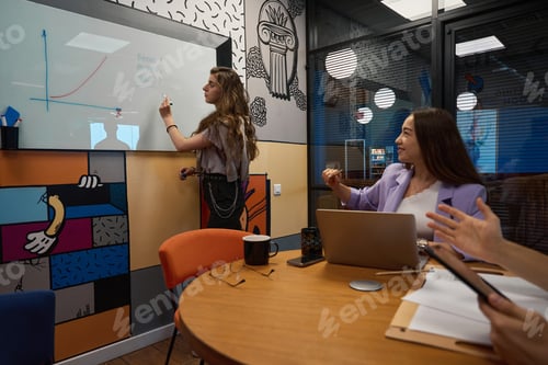 Preview: Young employee draws a schedule for colleagues on special board
