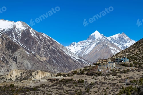 Preview: Snowy mountains range in Yak Kharka in Tanki Manang Village in Nepal under blue sky