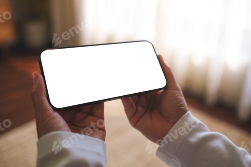 Preview: Mockup image of a woman holding mobile phone with blank desktop white screen at home