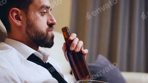 Preview: Side view of businessman drinking beer