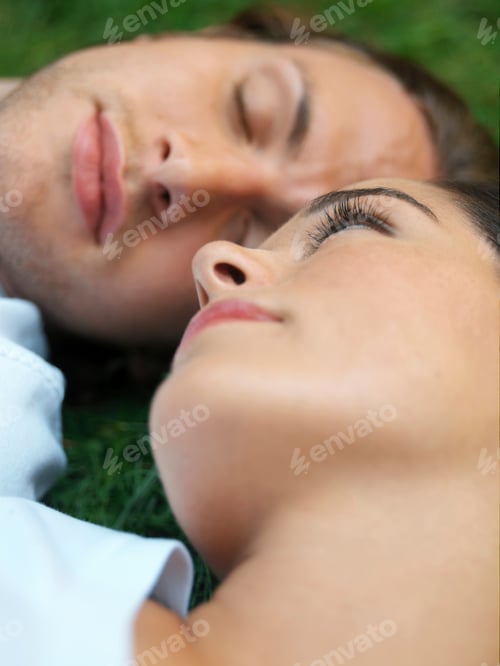 Preview: Young couple sleeping in field