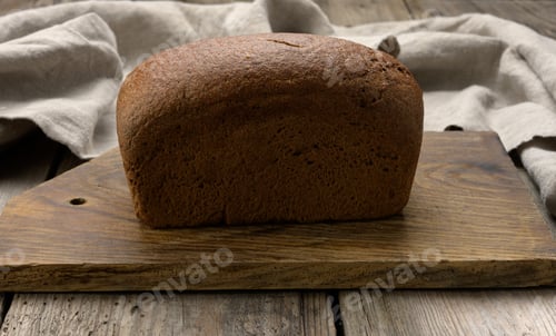 Preview: Baked rectangular rye flour bread on brown board, healthy food