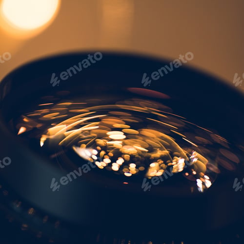 Preview: close-up shot of holiday lights reflecting in glass of camera lens