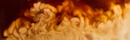 Preview: close up view of coffee mixing with milk in glass, panoramic shot