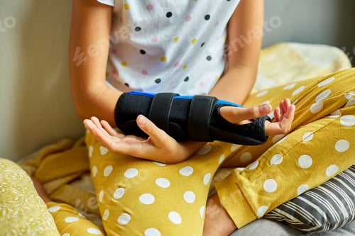 Preview: Young Girl Wearing a Hand Brace Sitting Thoughtfully by the Window