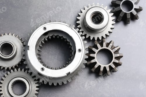 Preview: Different stainless steel gears on grey background, flat lay