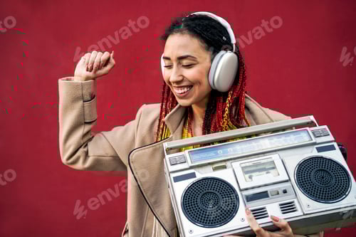 Preview: African girl dancing listening music in spring time outdoors - Focus on headphones