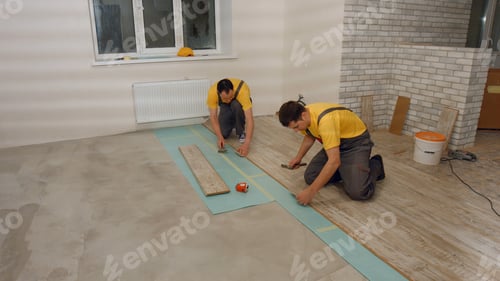 Workers Installing New Flooring in Home Renovation Project