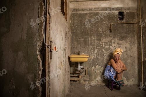 Preview: Cheap Accommodation. A Girl Sits On A Chair In An Old Apartment