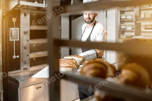 Preview: Baker with baked breads at the bakery