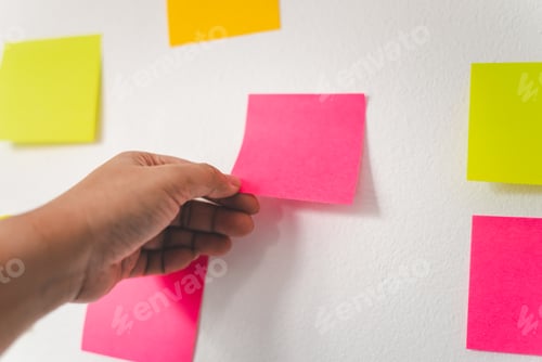 Preview: The hand is holding the post it notes attached to the wall. Concept brainstorming, share idea.