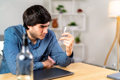 Preview: Young man struggling with alcohol addiction at home