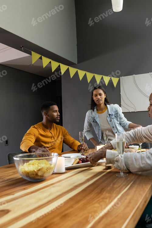 Preview: Friends enjoying snacks and drinks at home during festive celebration