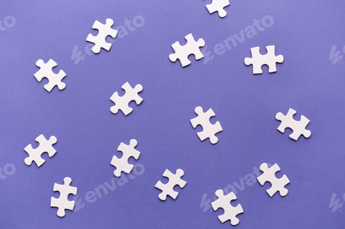 Preview: Pieces of jigsaw puzzle scattered on purple background