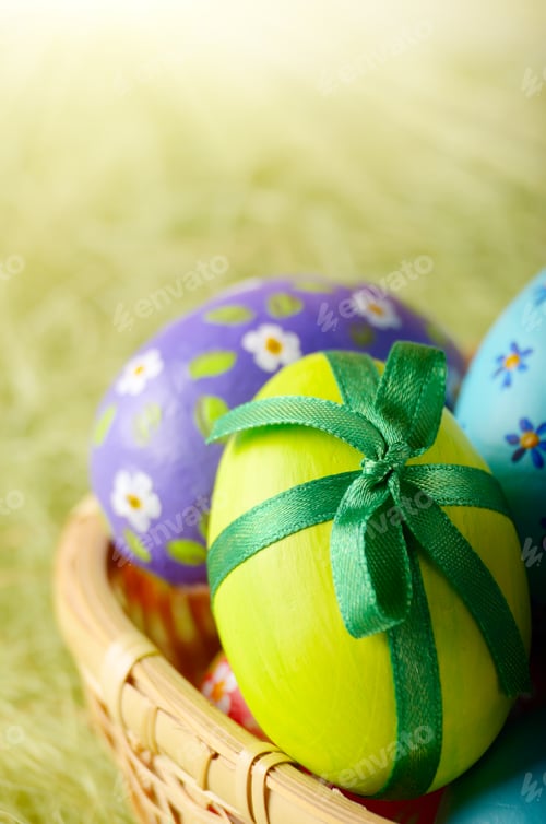 Preview: Rustic style painted easter eggs in basket on green background
