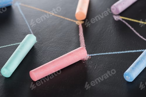 Preview: selective focus of colorful chalk on black surface with connected drawn lines, connection and