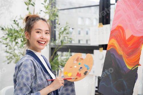 Preview: Young serious Asian woman Artist painting artwork at home workspace.