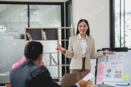 Preview: young asian businesswoman confidently presenting charts and graphs during a corporate meeting.