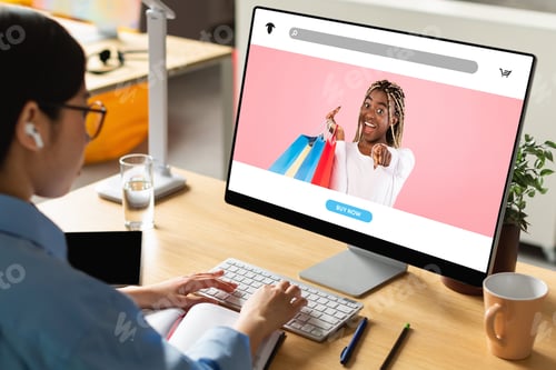 Preview: Young asian lady using new shopping website on modern computer at home or office, choosing clothes