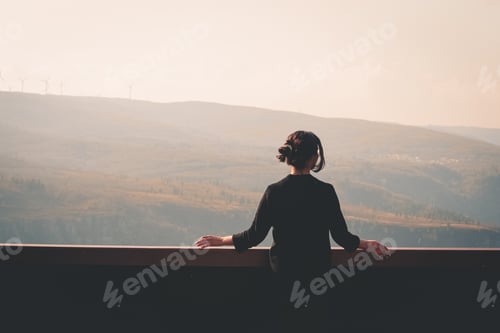 Preview: Young beautiful woman traveler looking at sunset and beautiful landscape with a lookout