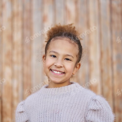 Preview: portrait of a latina girl with curly hair and ponytail smiling looking at the camera