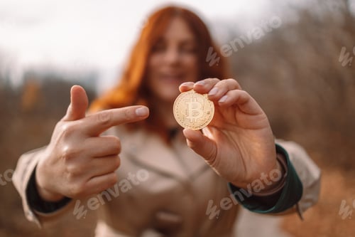 Preview: Golden bitcoin in a business woman hand outdoors. Cryptocurrency concept