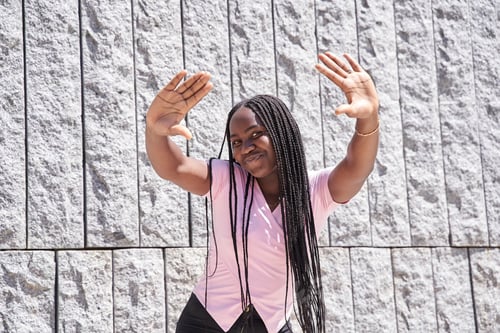 Preview: teenage woman with braids and arms around her waists
