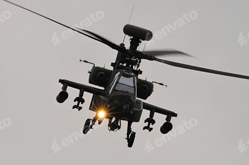 Preview: Military helicopter in flight with a front light on during a cloudy day