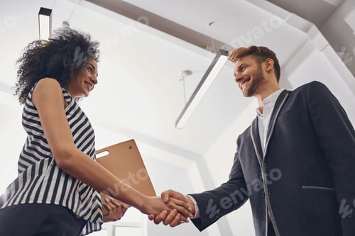 Preview: Two smiling business people greeting each other