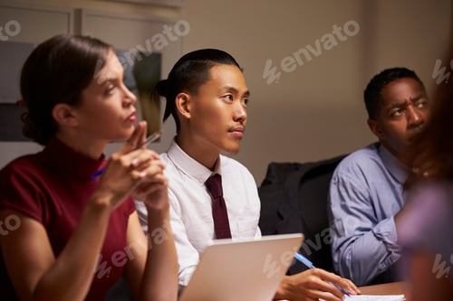 Preview: Business colleagues listening at evening meeting, close up