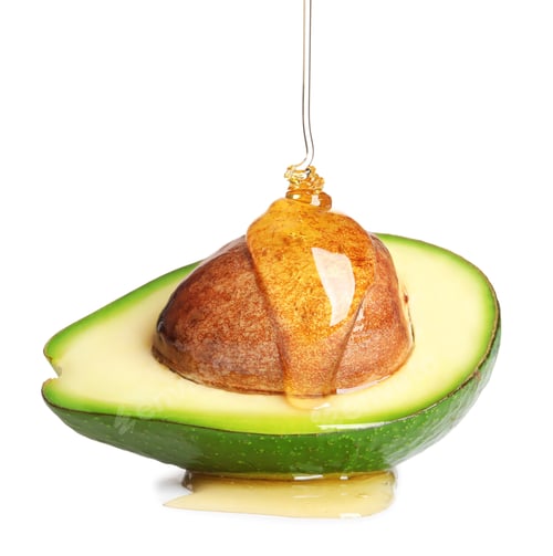 Preview: Pouring essential oil onto cut avocado on white background