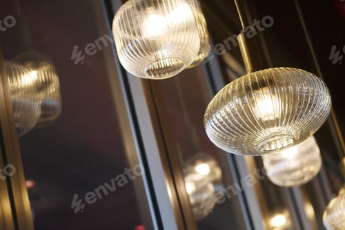 Preview: Hanging glass lights illuminate a cozy space in a restaurant