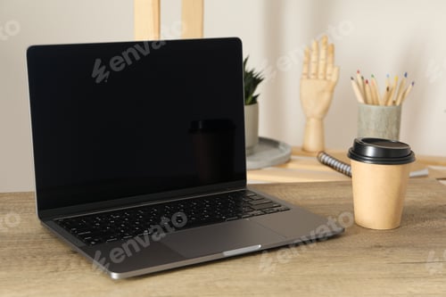 Preview: Open laptop on the table with a cup of coffee