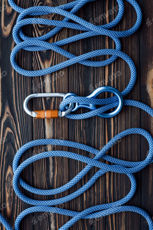 Preview: Isolated photo of climbing equipment. Parts of carabiners lying on the wooden table