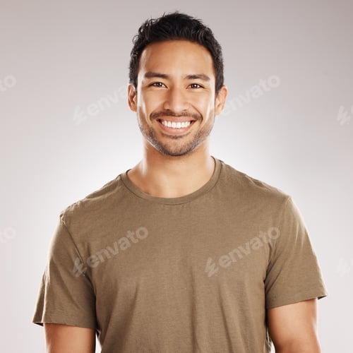 Preview: Handsome young mixed race man smiling and happy while standing in studio isolated against a grey ba
