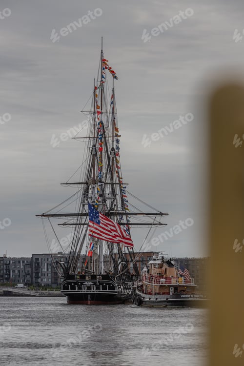 Preview: Vertical shot of the historic USS Constitution moving through the Boston harbor
