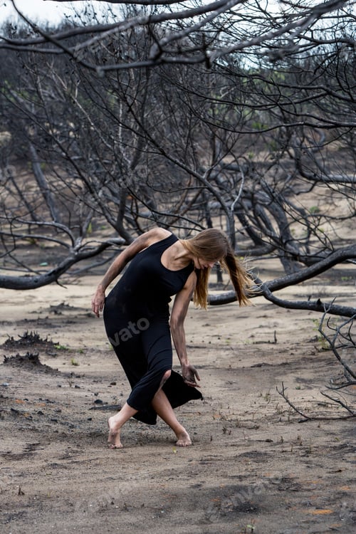 Preview: Woman dancing between dry trees