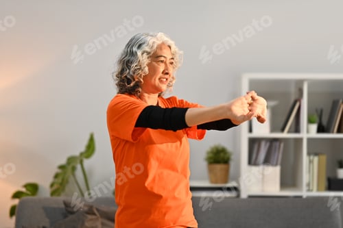 Preview: Active middle lady doing stretching exercises during home workout. Healthy lifestyle concept.