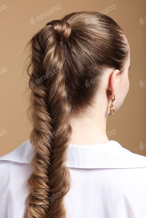 Preview: Woman with braided hair on brown background, back view