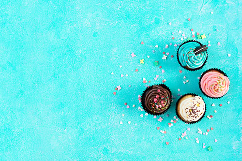 Preview: Tasty colorful cupcakes isolated on blue background. Delicious cupcake