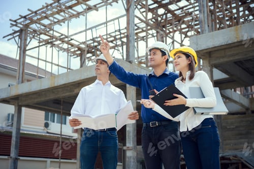 Preview: Asian Architector and engineers team with draft plan of building and tablet talking constructing.