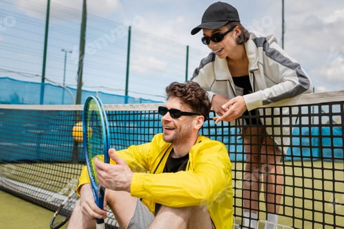 Preview: happy man and woman in active wear resting near tennis net on court, sportswear fashion, sport