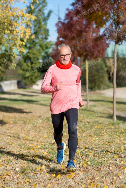 Preview: Senior man wearing glasses jogging at the park