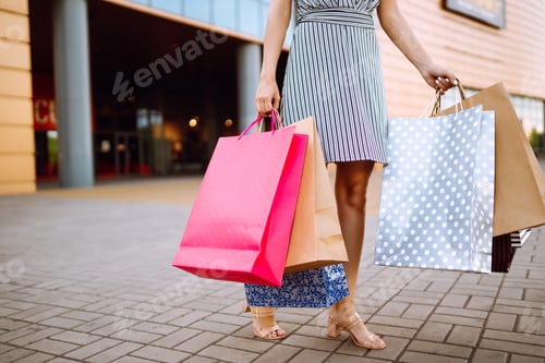 Preview: Shopping time. Young woman with shopping bags near the mall. Consumerism, sale, purchases.