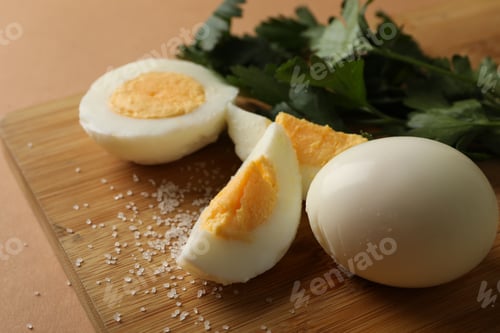 Preview: Board with boiled eggs, salt and parsley on brown background
