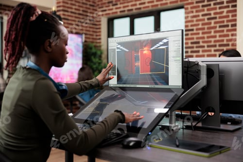 Preview: Developing company employee working at computer with two monitors while editing level environment.