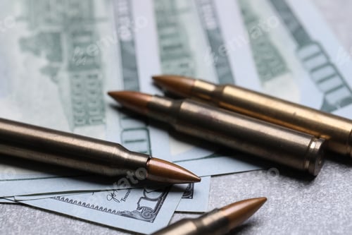 Preview: Firearm cartridges and dollars on grey table, closeup