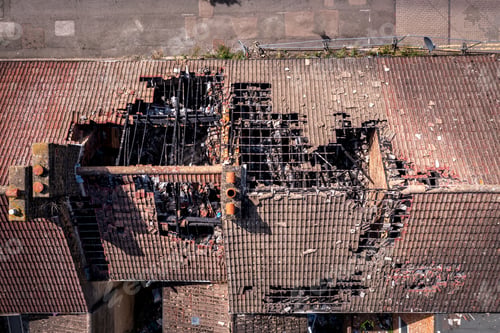 Preview: Aerial view directly above the roof of derelict terraced houses after a house fire