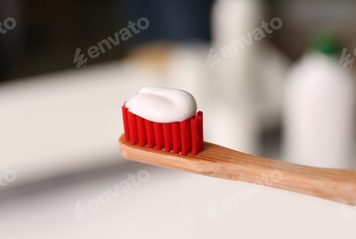 Preview: Toothbrush with paste on blurred background, closeup